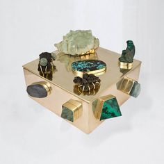 a table topped with gold and green items on top of each other's sides