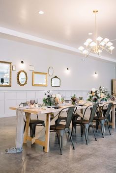 a dining room table is set with flowers and greenery for an elegant dinner party