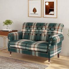 a living room with a plaid couch and two framed pictures on the wall above it