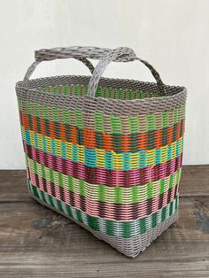 a multicolored basket sitting on top of a wooden table