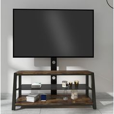 a flat screen tv sitting on top of a wooden stand next to a potted plant