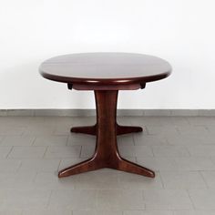 a wooden table sitting on top of a tiled floor