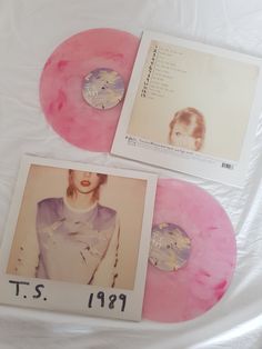 two pink and white colored records sitting on top of each other