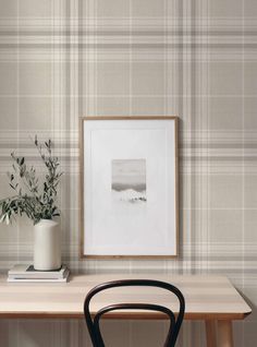 a wooden table with a plant on it next to a wallpapered wall in a room