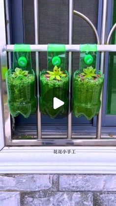 three green vases with plants in them on a window sill