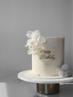 a birthday cake with white flowers on top