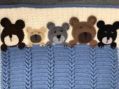 crocheted teddy bears are lined up in a row on top of a blanket