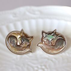 Mother of Pearl Golden Fox Earrings Bezel Set Sterling Silver Adorable Handcrafted Fox Gift for Fox Lovers Carved Sleeping Baby Fox Earrings Adorn yourself with this charming necklace featuring a mother of pearl earrings carved into an adorable sleeping fox. Set in a bezel with delicate milgrain detailing, the carving captures the serene beauty of a resting feline. The high-quality sterling silver chain complements the pendant, adding a touch of elegance and durability. Perfect for fox lovers and fans of unique, handcrafted jewelry, the earrings bring a playful yet sophisticated touch to any outfit. Whether a special gift or a delightful addition to your collection, this piece is sure to enchant and impress. Measurement: Each fox 20*23mm.  Material: Hand-carved mother of pearl  925 silver. Fox Signet Ring, Fox Ring Gold, Fox Jewelry Ring, Fox Jewelry Necklace, Fox Earrings, Fox Lover, Foxes Necklace, Fox Gift, Mother Of Pearl Earrings