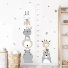 a child's room with a height chart and wall decals in the shape of animals