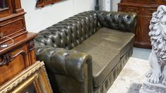 a leather couch sitting next to a lion statue