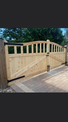 a large wooden gate on top of a brick walkway