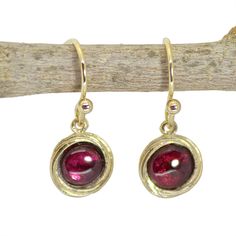 Garnet dangle earrings The garnet is January's birthstone, and it symbolizes peace, prosperity and good health. Some say it even has the power to give the wearer eternal happiness, health and wealth. 🌸 Product details: Handmade earrings 🌸 Measurements: Weight - 2.2 g Length - 1.02" (2.6 cm) Width - 0.35" (0.9 cm) Stone Diameter - 0.23" (6 mm) 🌸Materials: 14k gold plating over brass Genuine garnet 🌸 More info: All my jewelry is carefully wrapped and shipped in a lovely gift box, ready to be g Garnet Gemstone Drop Earrings, Single Ruby Earring As A Gift, Nickel Free Ruby Earrings As A Gift, Nickel-free Ruby Earrings As A Gift, Nickel-free Ruby Earrings For Gift, Garnet Drop Earrings As Gift, Garnet Drop Earrings With Matching Set, Garnet Drop Earrings With Ear Wire, Red Birthstone Earrings As Gift