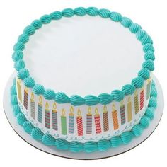 a birthday cake decorated with candles on a white plate and blue ribbon around the edges