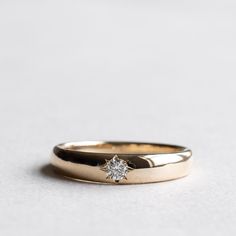 two gold wedding bands with a single diamond