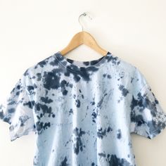 a blue and white tie dye shirt hanging on a wall