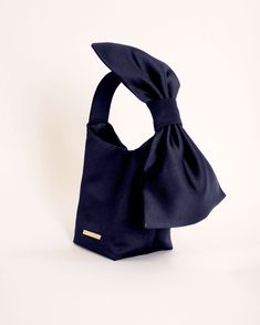 This Camilyn Beth satin Bow Handbag is the perfect combination of chic and unique! A must-have accessory to pair with your Camilyn Beth Design. Details: Satin handbag with adjustable bow detail at handleClosure: MagneticCare: Spot CleanMaterial: Satin Polyester Dimensions: 5" X 4" X 6" Made in: Sarasota, FL. Evening Rectangular Shoulder Bag With Detachable Bow, Rectangular Shoulder Bag With Detachable Bow For Party, Chic Clutch Bag With Bow, Rectangular Evening Shoulder Bag With Detachable Bow, Chic Rectangular Shoulder Bag With Bow, Chic Rectangular Bag With Detachable Bow, Chic Shoulder Bag With Detachable Bow, Rectangular Shoulder Bag With Bow For Shopping, Chic Evening Shoulder Bag With Bow