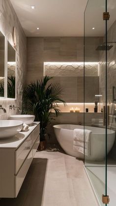 a bathroom with two sinks and a bathtub next to a large mirror on the wall