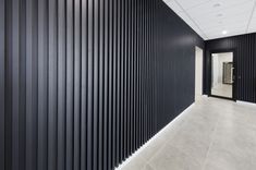 an empty hallway with black vertical slats on the wall