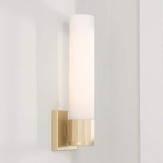 a bathroom light that is on the side of a wall with a white glass shade