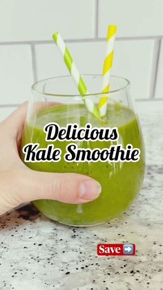 a hand holding a glass filled with green smoothie