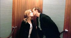 a man and woman kissing in an elevator