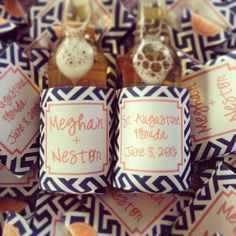 wedding favors with name tags on them sitting on a blue and white pattern table cloth