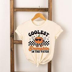 Looking for a cute tee for your kids? We have the perfect Coolest Pumpkin In The Patch graphic tee addition to their closet! Cool Graphic Print Tops For Fall, Retro Slogan T-shirt For Fall, Cool Crew Neck T-shirt With Funny Print, Fun Fall Screen Print T-shirt, Fun Fall T-shirt With Screen Print, Fun Screen Print T-shirt For Fall, Fun Fall T-shirt With Funny Print, Fall Cotton T-shirt With Funny Print, Cute Fall T-shirt With Screen Print