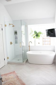 a white bath tub sitting next to a walk in shower