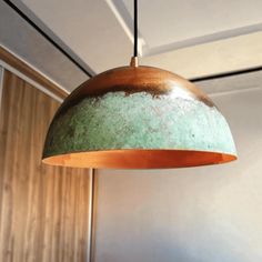 a green and brown light hanging from a ceiling