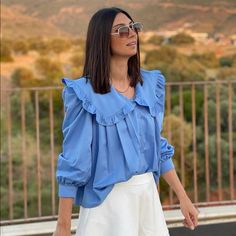 Details: Round Neck Blouse Peter Pan Collar Ruffled Self Appliqu Long Sleeves With Pleated Cuffs Front Pleated Button Buttoned Shirt Straight Hem Fabric: Cotton Light Blue Collared Spring Blouse, Blue Long Sleeve Ruffled Shirt, Spring Light Blue Collared Blouse, Blue Collar Blouse For Spring, Blue Blouse With Ruffled Collar And Details, Blue Spring Blouse With Collar, Elegant Blue Blouse With Ruffled Collar, Chic Blue Shirt With Ruffles, Elegant Blue Top With Ruffled Collar