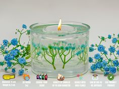 a glass jar with blue flowers and a lit candle in it next to other items