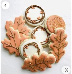 cookies decorated with icing and sprinkles are arranged in the shape of leaves