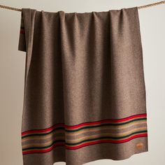 a brown blanket hanging on a clothes line with a red, yellow and green stripe