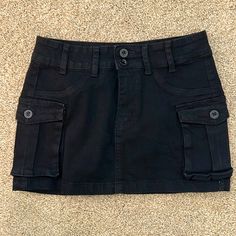 Brand New, Never Worn Mini Skirt In Black. Ordered A Medium And It’s Definitely A Small Y2k Style Black Skirt With Pockets, Black Y2k Skort With Pockets, Y2k Black Skort With Pockets, Edgy Black Mini Cargo Skirt, Casual Black Cargo Skirt For Spring, Y2k Black Cotton Skort, Black Cotton Mini Cargo Skirt, Black High Waist Cotton Cargo Skirt, Trendy Black Cotton Cargo Skirt