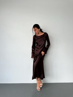 Cette superbe robe longue chocolat est confectionnée dans un luxueux satin de soie italien dense, offrant un drapé doux et élégant. La robe présente des manches longues et un décolleté sophistiqué, parfait pour les événements formels, les tenues de soirée ou toute occasion spéciale où vous souhaitez faire une déclaration. Avec son design minimaliste et son savoir-faire impeccable, cette robe deviendra un ajout intemporel à votre garde-robe. Son style polyvalent permet de l'habiller facilement av Long Sleeve Formal Gown, Satin Long Sleeve, Elegant Drapes, Brown Silk, Satin Color, Formal Gown, Dress Clothes For Women, Silk Satin, Evening Wear