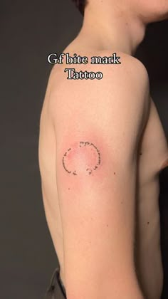 a woman with a small tattoo on her shoulder and chest, the words get bite mark tattoo