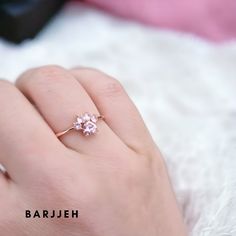 a woman's hand with a pink diamond ring on top of her left hand