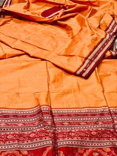 This handloom saree is a beautiful Ikat woven by a master weaver. It is a luxurious silk saree perfect for a grand celebration like wedding or a milestone birthday! This saree has intricate Ikat patterns in the pallu and an amazing flame orange  body. Created in a small town in the state of Orissa, India, It is lightweight and carries like a dream. You will enjoy draping this beautiful work of art.  This saree was made by weavers located in Sambhalpur and curated by SilkSaga.  It comes with an u Unstitched Silk Traditional Wear For Rituals, Handloom Pre-draped Saree For Diwali Rituals, Festive Silk Saree For Rituals, Orange Dupatta With Weaving Work In Traditional Drape, Orange Art Silk Dupatta With Weaving Work, Raw Silk Handloom Dupatta For Rituals, Handloom Art Silk Saree For Rituals, Silk Dupatta With Zari Weaving For Rituals, Silk Traditional Wear For Navratri Rituals