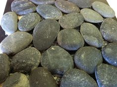 some rocks are laying on top of each other and one is black with white speckles