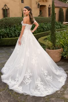 a woman in a white wedding dress standing outside