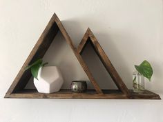 two wooden shelves with plants and vases on them in the shape of trianglees