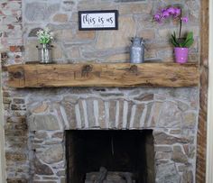 a stone fireplace with some flowers on the mantle