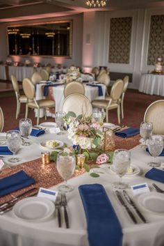 the tables are set with silverware and blue napkins for an elegant wedding reception