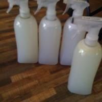 four white spray bottles sitting on top of a wooden floor