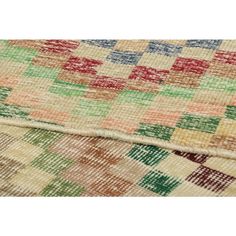 an old rug with multicolored squares on it