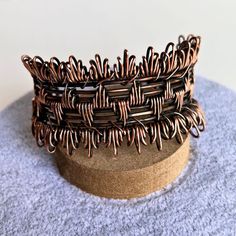 You'll love this wide, chunky, one-of-a-kind artisanal copper wire cuff. Handcrafted with copper wire, this cuff features intricate details and an adjustable fit. Oxidized and hand polished, this cuff has been coated to preserve the finish. I love the fringe effect on the wrapping on the top and bottom. One size fits most - adjust by gently pulling and squeezing the sides Copper wire Handmade in Lincoln, Nebraska Handmade Copper Wire Cuff Bangle, Handmade Copper Wire Cuff Bracelet Bangle, Bohemian Copper Wire Cuff Bangle Bracelet, Handmade Bohemian Copper Wire Cuff Bracelet, Unique Copper Wire Wrapped Cuff Bracelet, Unique Copper Wire Cuff Bracelet Gift, Handmade Adjustable Copper Cuff Bracelet, Adjustable Wire Wrapped Bronze Cuff Bracelet, Bohemian Copper Wire Wrapped Cuff Bracelet