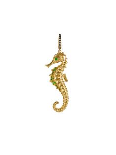 a gold seahorse charm with green stones on it's back end and an 18k yellow gold chain