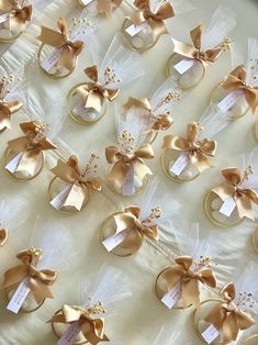 gold wedding rings with bows and tags are on a white tablecloth that is covered in tulle