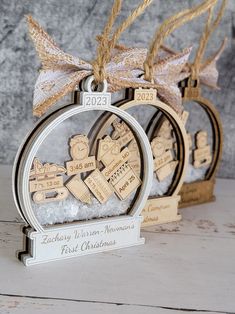 two wooden christmas ornaments hanging from twine