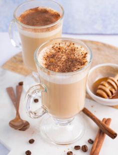 two glasses of hot chocolate with cinnamon on the side